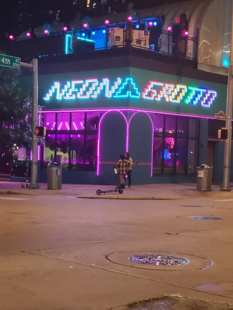 Neon Grotto exterior at night with its stepped multicolor neon sign