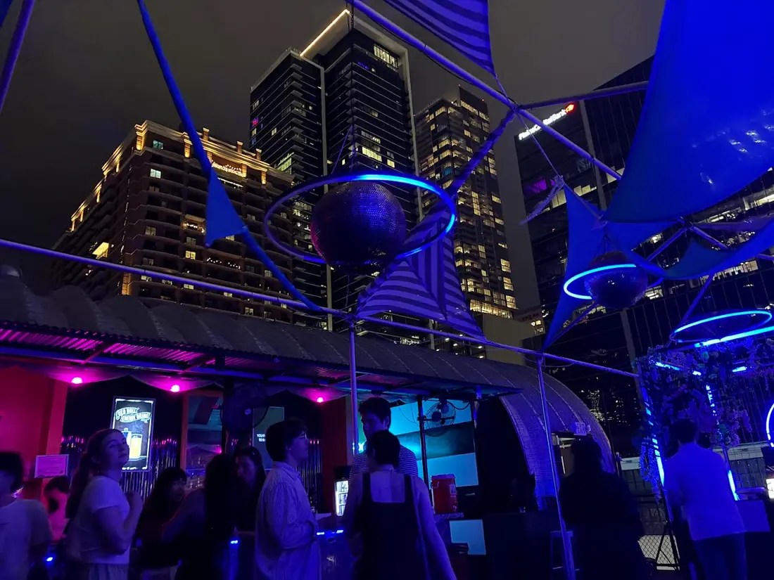Neon Grotto rooftop at night with blue-lit disco balls and the downtown skyline